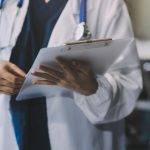 Portrait of a female US Civil Surgeon looking at a patient's chart.